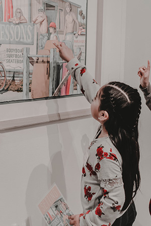 A girl points to a detail in a painting