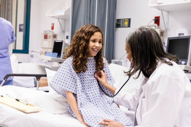 Girl smiles as the female doctor checks her heart with a stethoscope