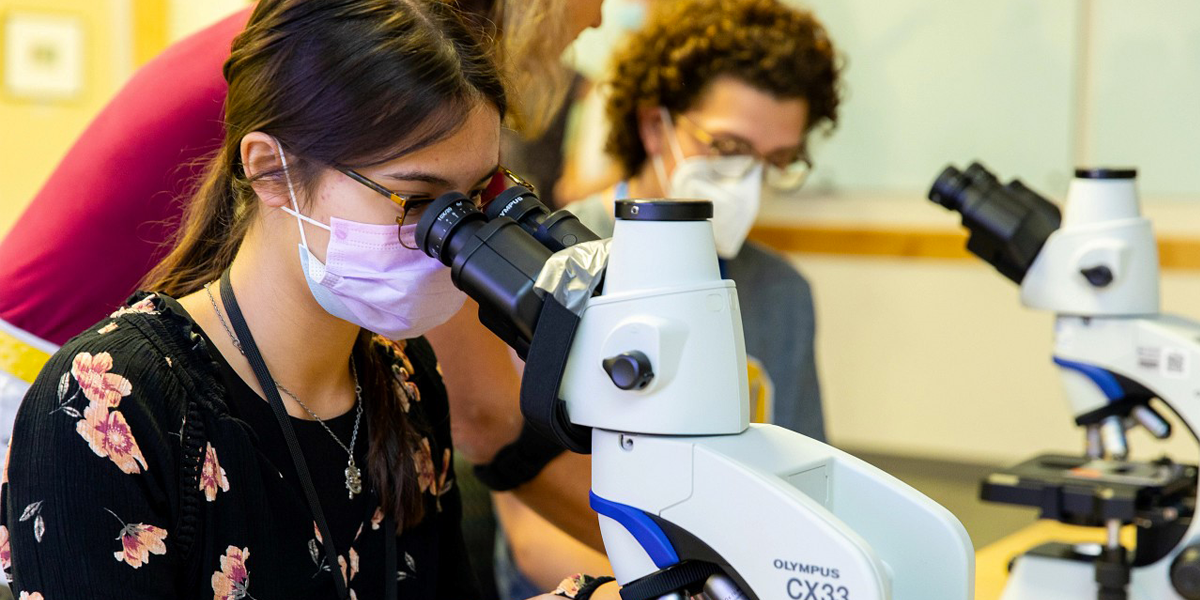 Salk Institute STEM student with microscope