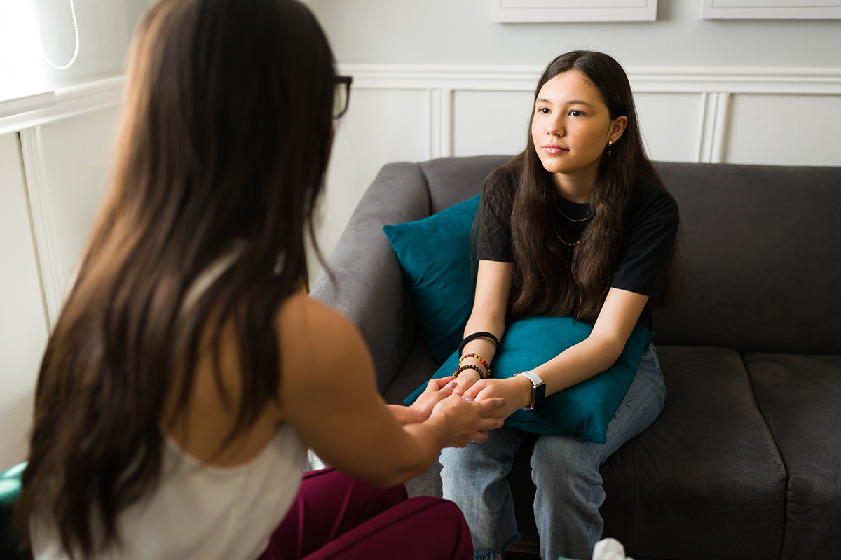 Psychologist reassuring a teen girl