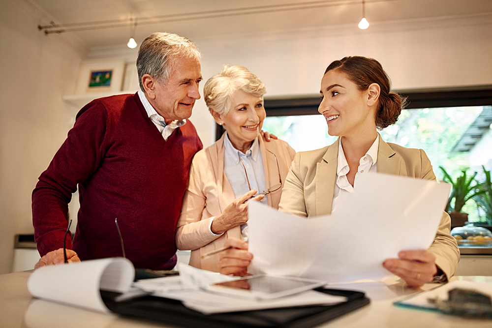 Senior couple, financial advisor and paperwork in discussion for budget or retirement plan at home. Happy elderly man and woman with consultant or lawyer and documents for planning