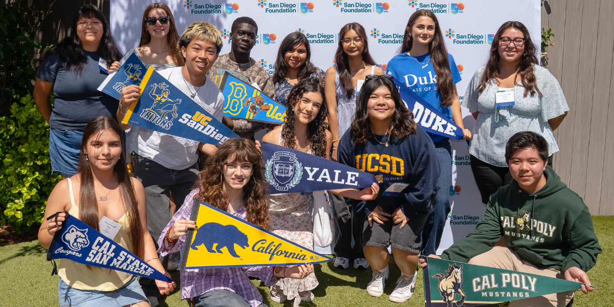 Students posing with college pennants at Scholarships Celebration 2025
