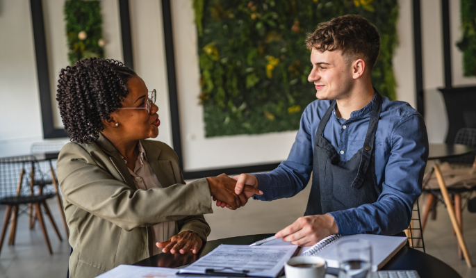 Business owner in a meeting shaking hands with a financial advisor
