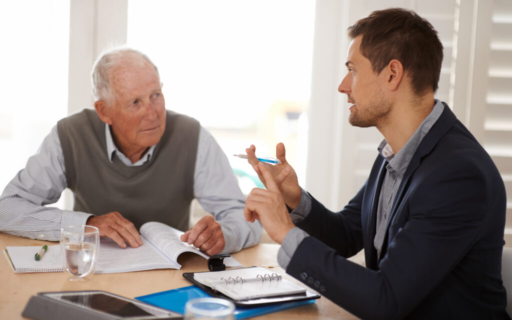 Financial advisor talking to a senior man with an investment, savings or retirement planning. Discussion, documents and professional accountant helping an elderly male person with finance paperwork