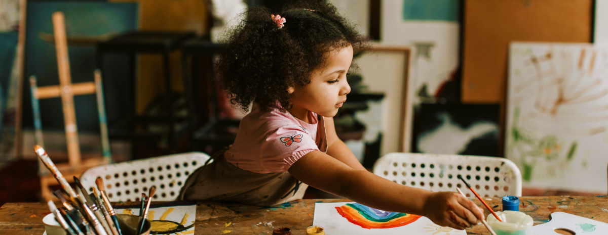 Young girl sitting at a desk doing a creative activity