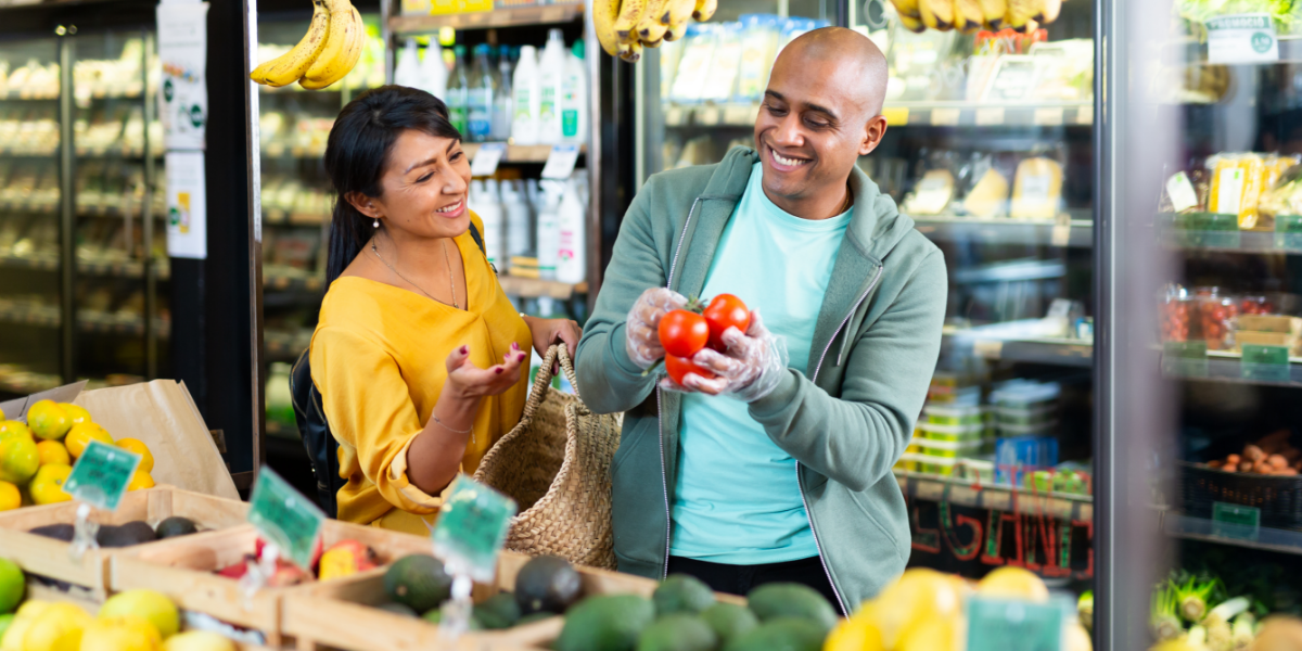 Latino couple looking at produce at the grocery store