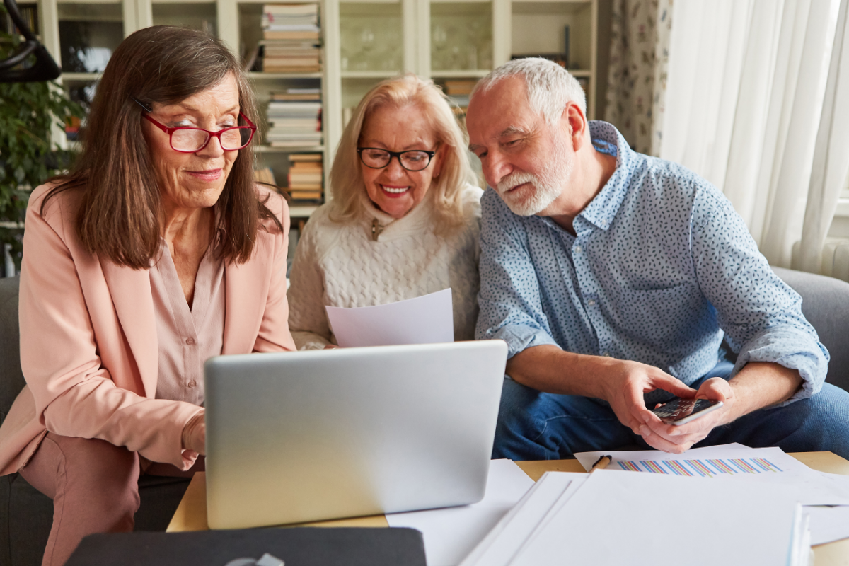 Couple with advisor at home looking at laptop