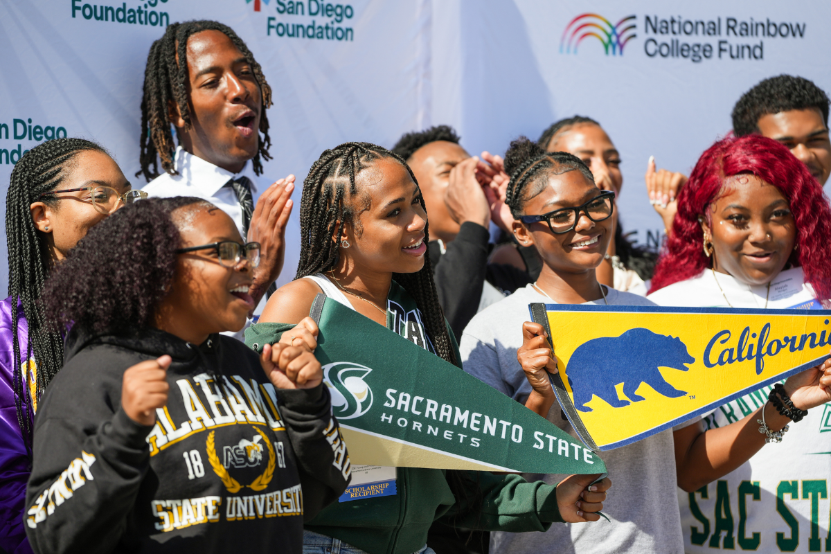 Scholarship recipients posing in front of the step and repeat backdrop